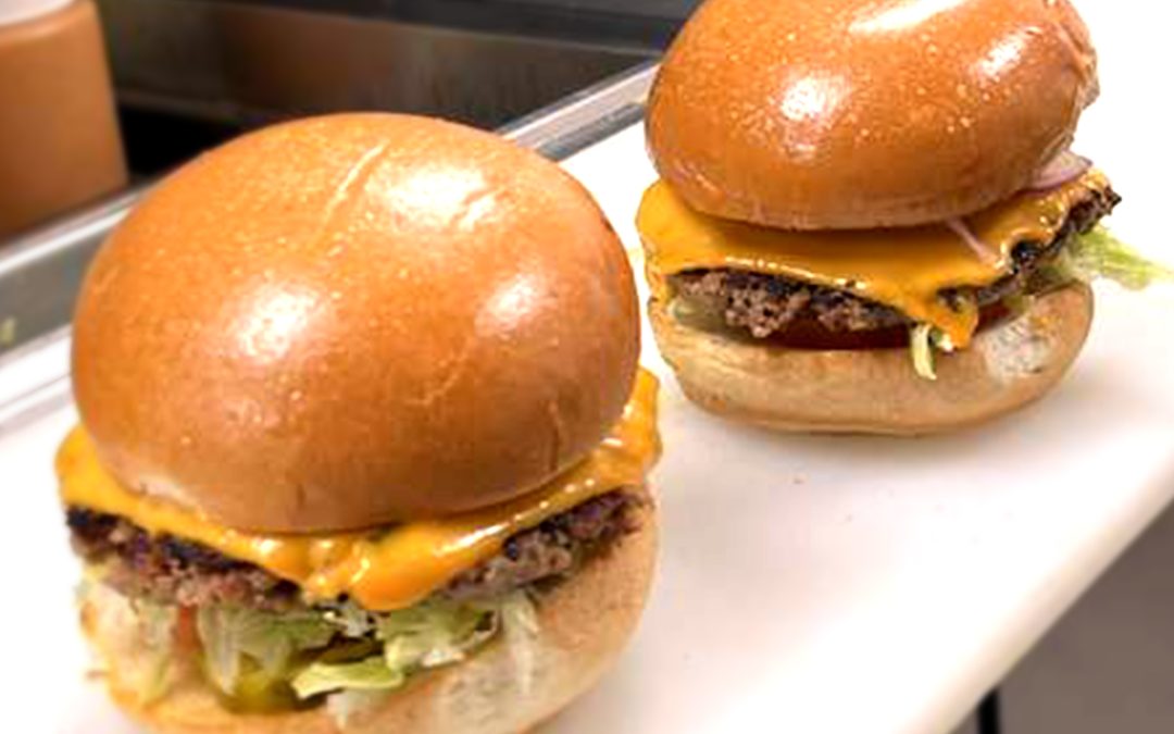 Gourmet burger at Wulf Burger Dallas with signature red and green buns