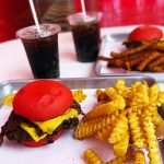 Wulf Burger smashburger with American cheese, grilled onions, pickles and garlic mustard aioli in Dallas Texas
